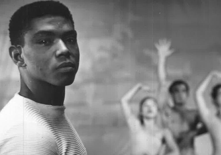 A portrait in b&w of Alvin Ailey, with three dancers in the background