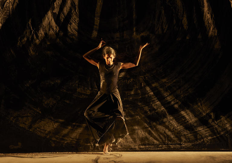 Woman dancing on stage with ash