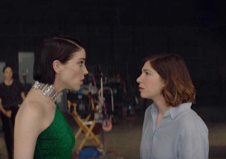 Annie Clark (St Vincent) and Carrie Brownstein (Sleater-Kinney) look at each other in portrait in a still from The Nowhere Inn