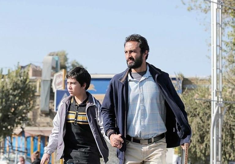 Still of Rahim and his son walking hurriedly 