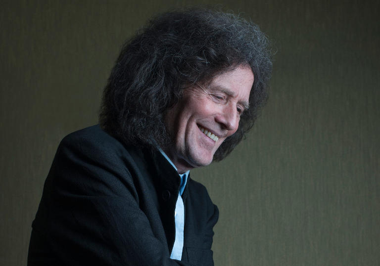 Gilbert O'Sullivan laughing, looking away from the camera