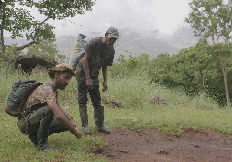 A still from The Road to Kuthriyar, two men in a forest