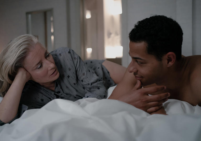 Emma Thompson and Daryl McCormack lie on a bed and look at each other