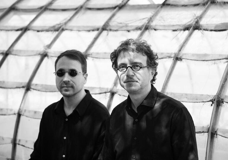Black and white photo of Donato Dozzy and Neel wearing glasses