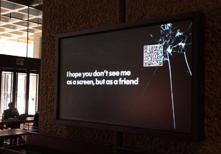 A screen on a concrete wall that says 'I hope you don't see me as a screen but as a friend'
