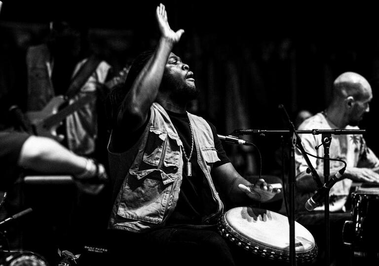 Black and white photo of Yahael playing a drum