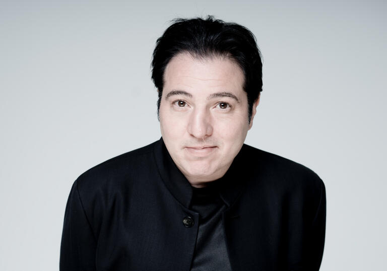 Fazil Say looking at the camera against a white backdrop