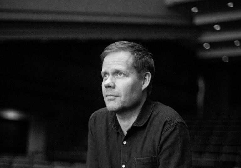 Black and white image of Max Richter in a music theatre, staring into the distance