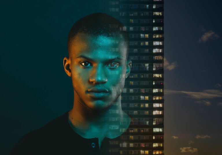 Black male portrait next to tower block