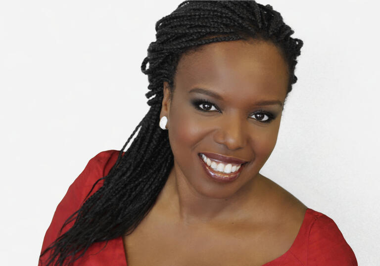 Nadine Benjamin smiling in front of a white background