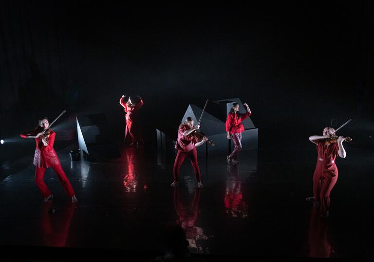The Regazze Quartet and Lucia Lucas performing on stage in red outfits