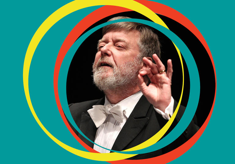 Sir Andrew Davis conducts, with green BBC SO branding around his centred image