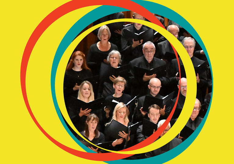 BBC Symphony Chorus are in the centre of the image, surrounded by yellow BBC Symphony Orchestra branding