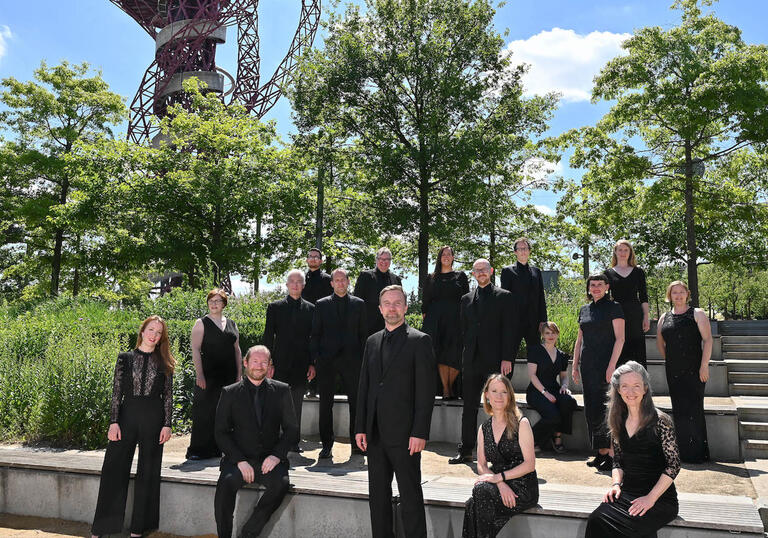 The BBC Singers stand in front of some trees
