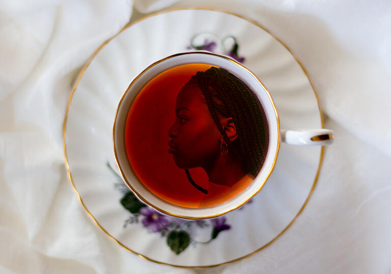 Image of a girl's face in profile in a china teacup