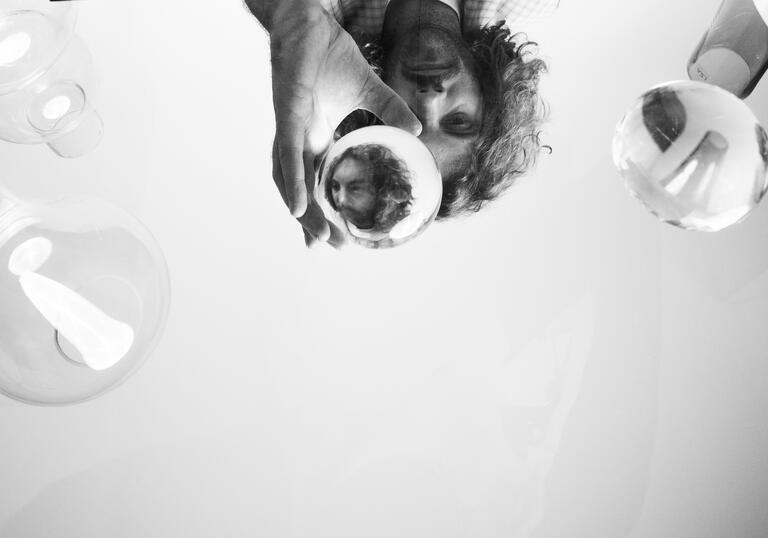 Black and white conceptual image of Blanco White peering through a glass ball