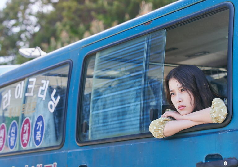 A woman leans out of a van in a still from Broker
