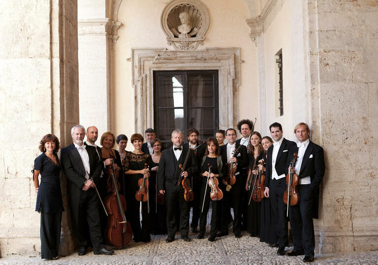 The members of Europa Galante standing in a line holding their instruments