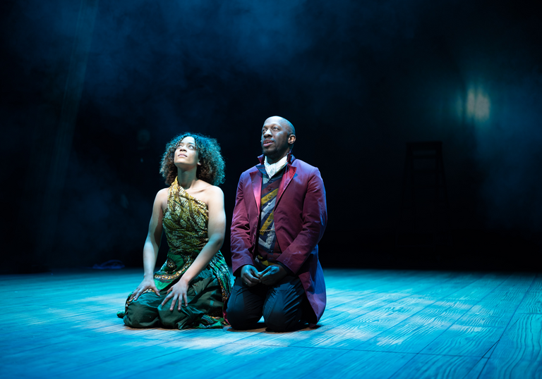 Giles Terera and Keira Lester kneeling on the floor on stage in The Meaning of Zong