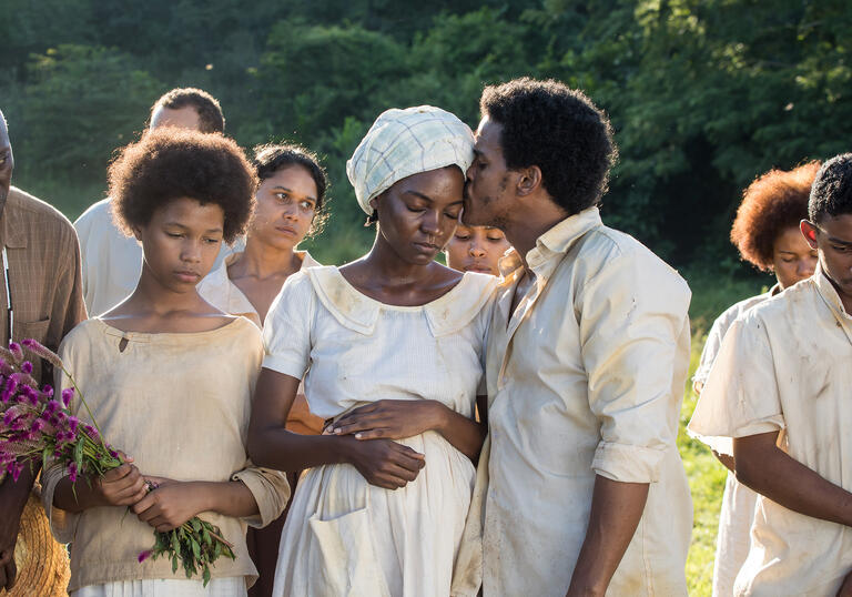 A man kisses a pregnant woman on the head in a still from Parsley.