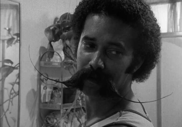 A still from a black and white film depicting a person of colour 