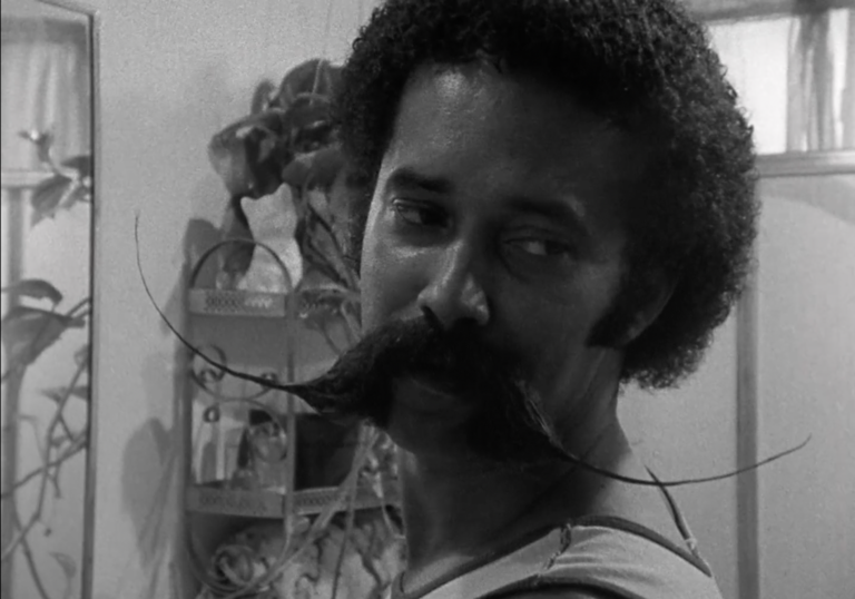 A still from a black and white film depicting a person of colour