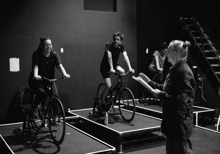 Director Katie Mitchell gives guidance to a cyclist who is on the stage 