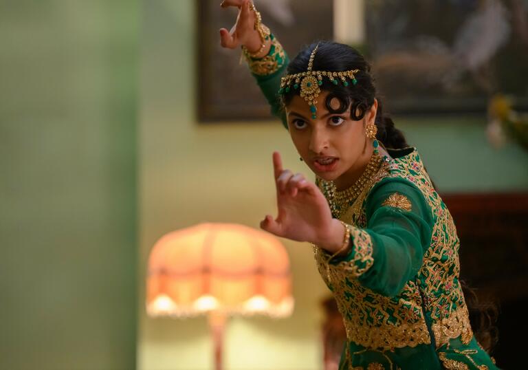 A girl takes a fight stance whilst in formal wear in a still from Polite Society