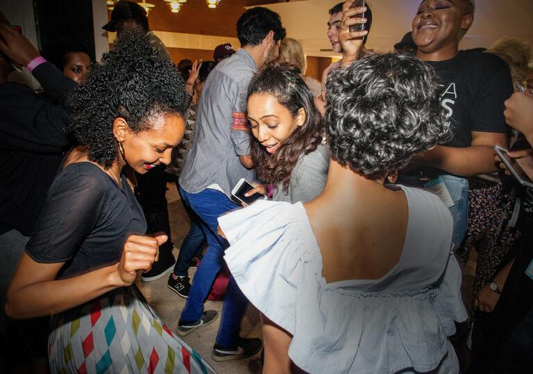 Inua Ellams R.A.P Party. Three people are dancing and smiling at an event.