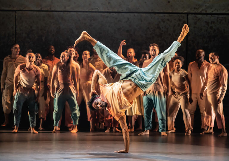 A performer break dances on a stage