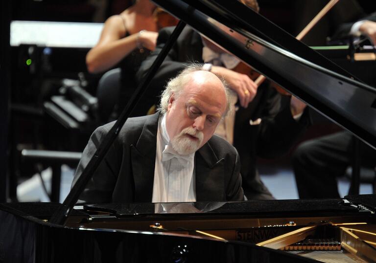 Peter Donohoe playing the piano on stage