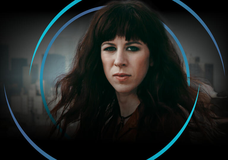 Missy Mazzoli looking at the camera, with circular blue swirls around her head