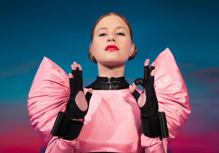 Chagall in a pink top with enlarged shoulders.