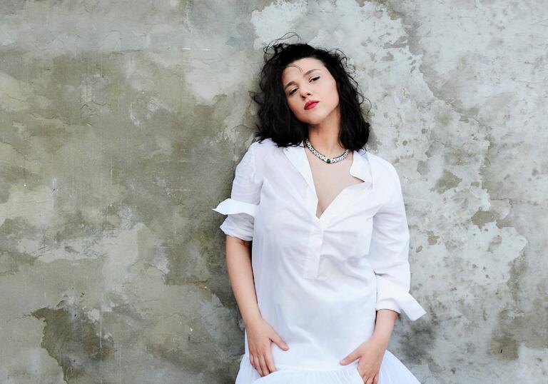 Khatia Buniatishvili standing against a stone wall