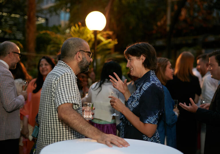 Gathering of guests at a champagne reception in the Barbican Conservatory