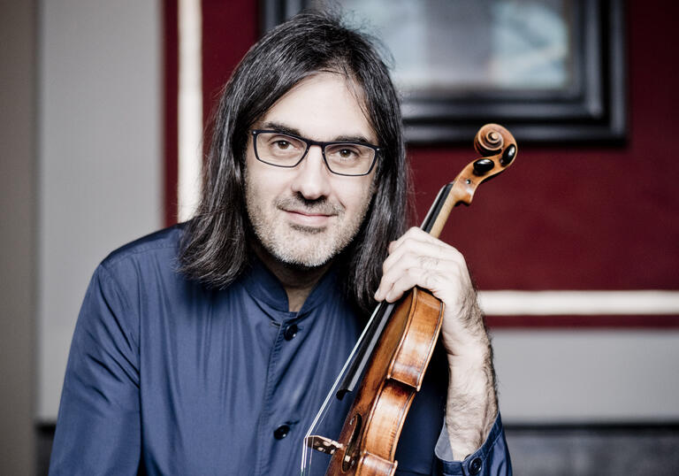 Leonidas Kavakos looking at the camera while holding his violin