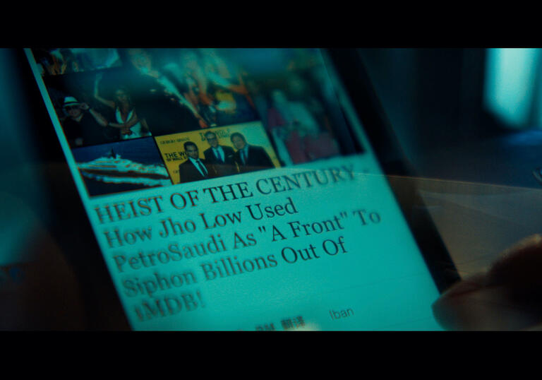 A photo of a phone screen with an article about a scandal on it.