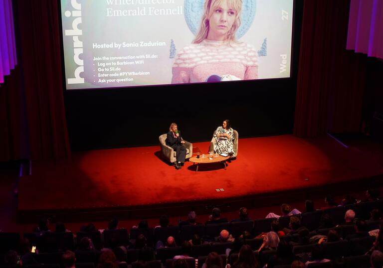 Emerald Fennell sits on a cinema stage and talks about film. 