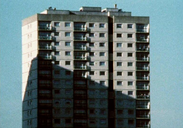 A tall sky scraper stands in the sun. 