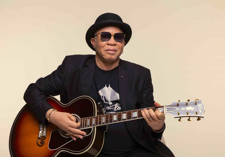 Salif Ketia sits holding guitar 