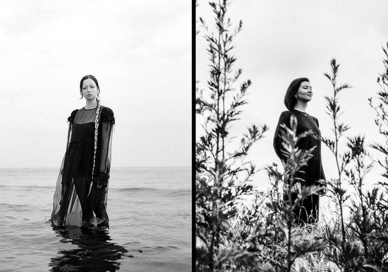 Lucinda Chua & Gayla Bisengalieva stand in landscape and black and white