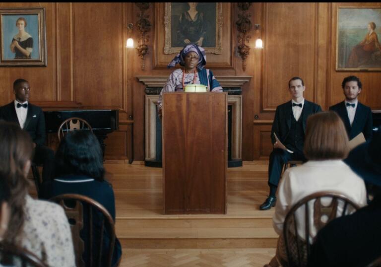  A woman stands at a podium addressing a crowd in a court.