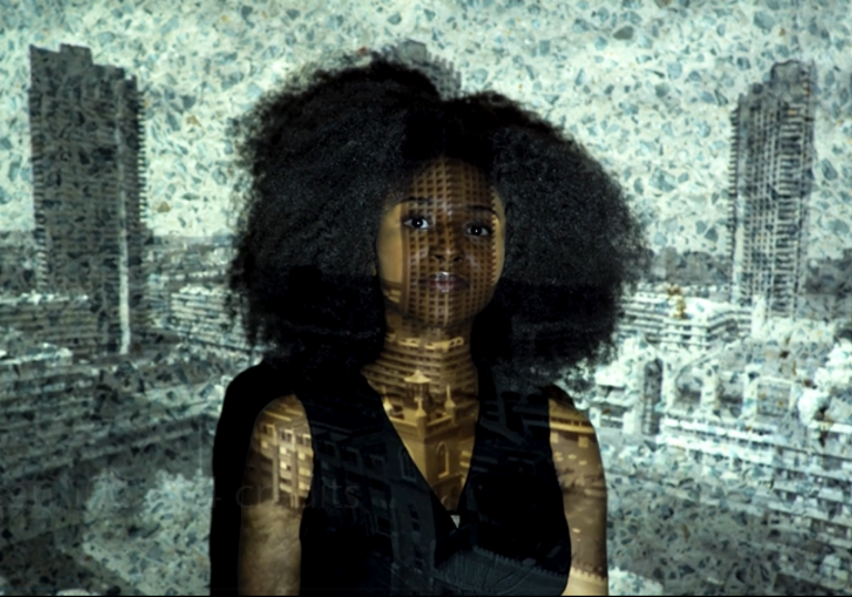 A woman stands in front of a hologram of the Barbican