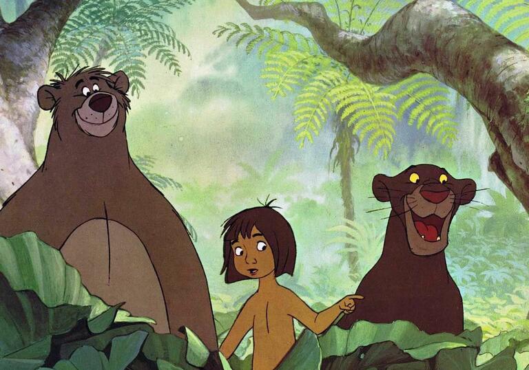 A young boy and a bear and a big cat stand in the jungle.