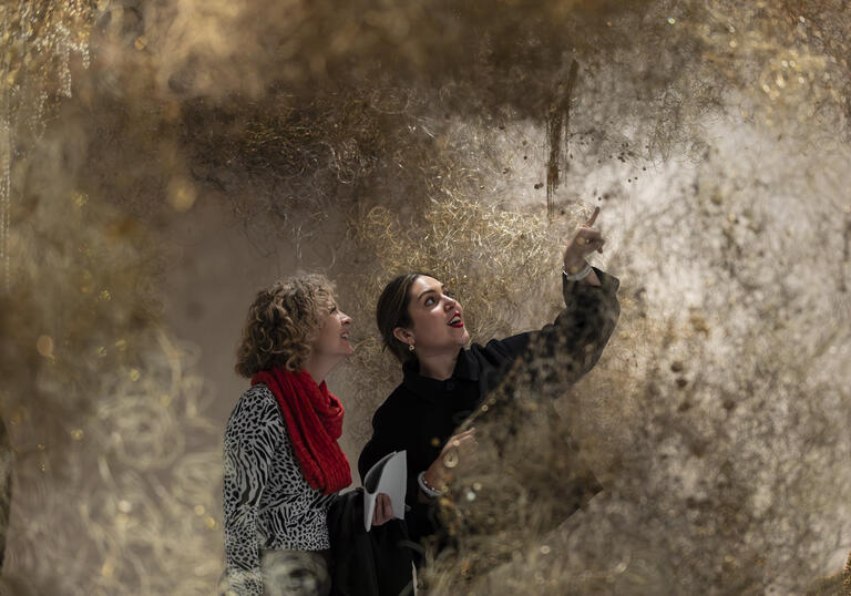 two people look at an art installation 