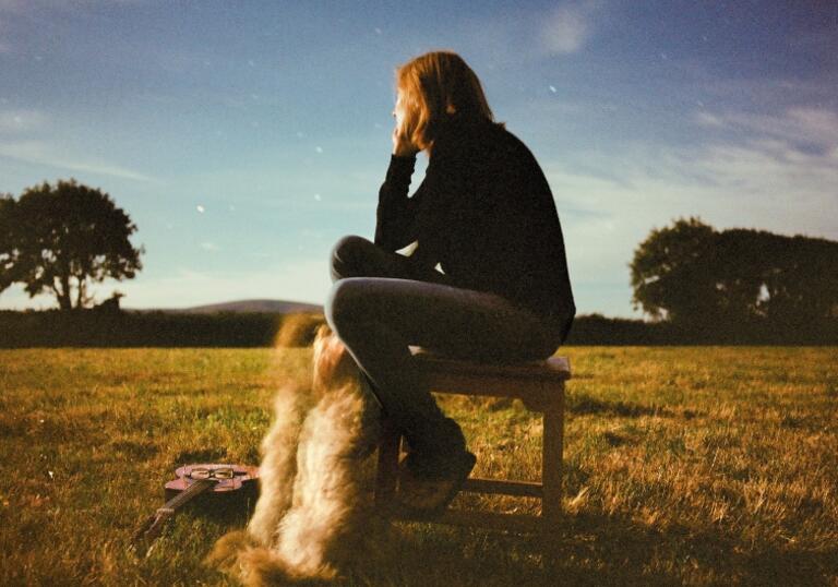 Beth Gibbons sitting on a chair under a starry sky