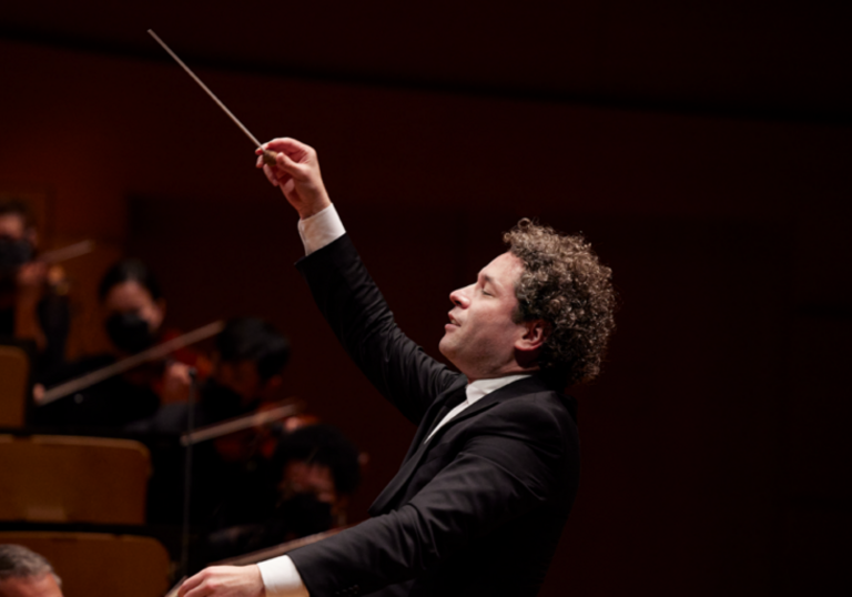 A side-on shot of Gustavo Dudamel conducting