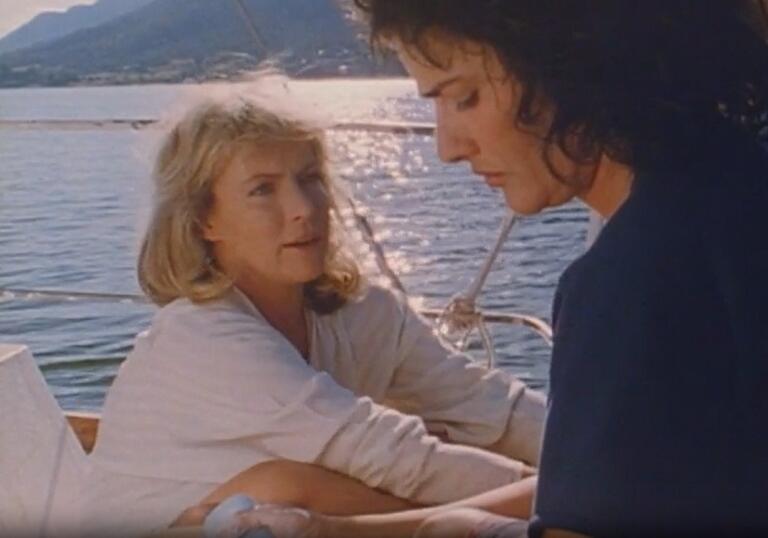 Two women chat on a boat on a glorious, sunny Mediterranean ocean.
