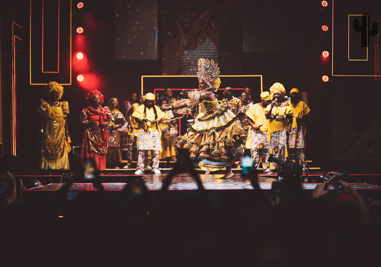 Ilê Aiyê performing on stage in traditional costume