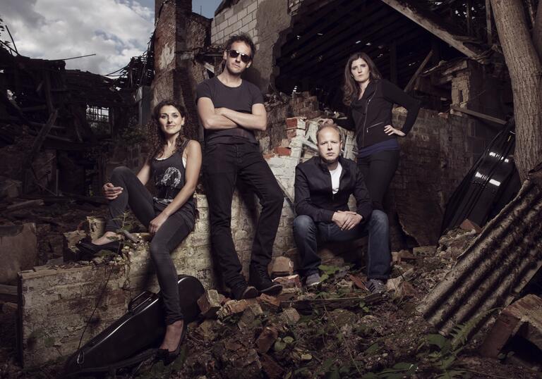 The Carducci Quartet sitting amongst the ruins of a brick building